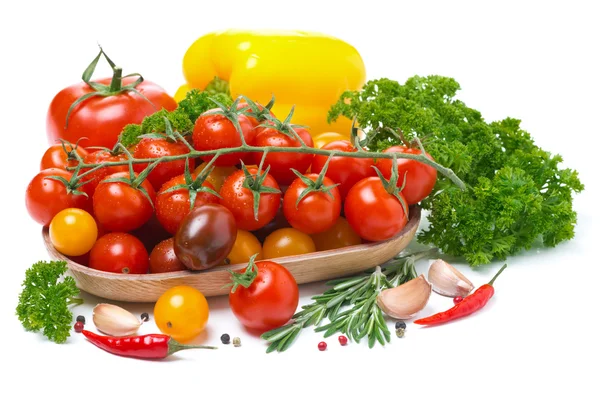 Colored cherry tomatoes in a wooden bowl, pepper, herb and spice — Stock Photo, Image