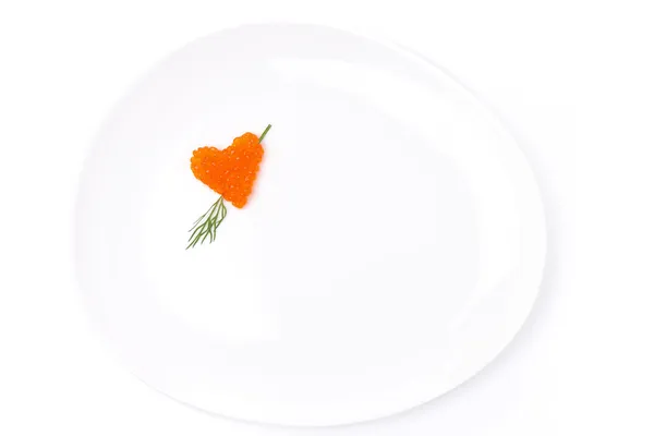 Herz aus rotem Kaviar mit Dill auf einem Teller, isoliert — Stockfoto