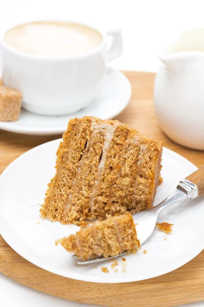 Pedaço de bolo de mel em um prato, garfo e xícara de cappuccino — Fotografia de Stock