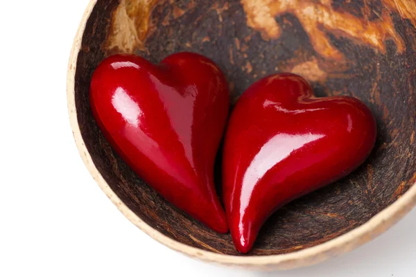 Dvě červené srdce v misce z kokosu, izolované — Stock fotografie
