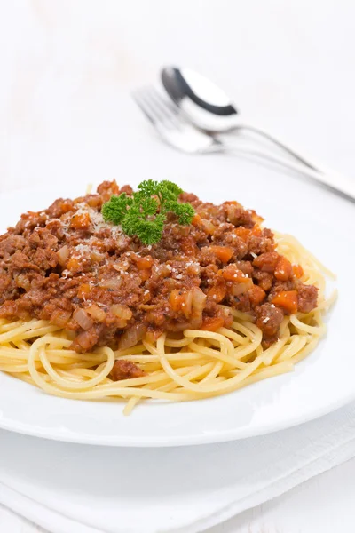 Portion of spaghetti bolognese on a white plate, vertical — Stock Photo, Image