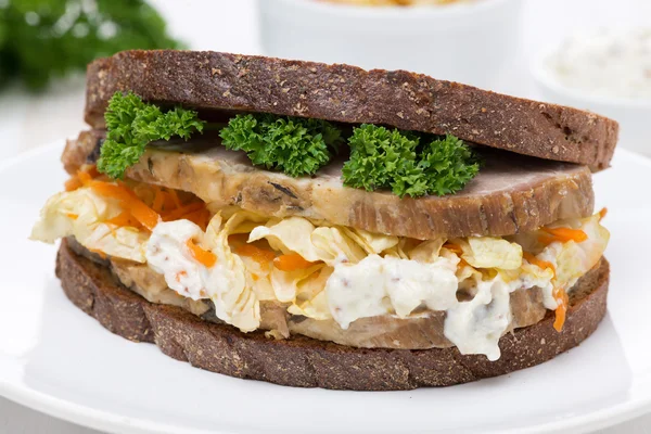 Sandwich of rye bread with coleslaw and baked meat, close-up — Stock Photo, Image
