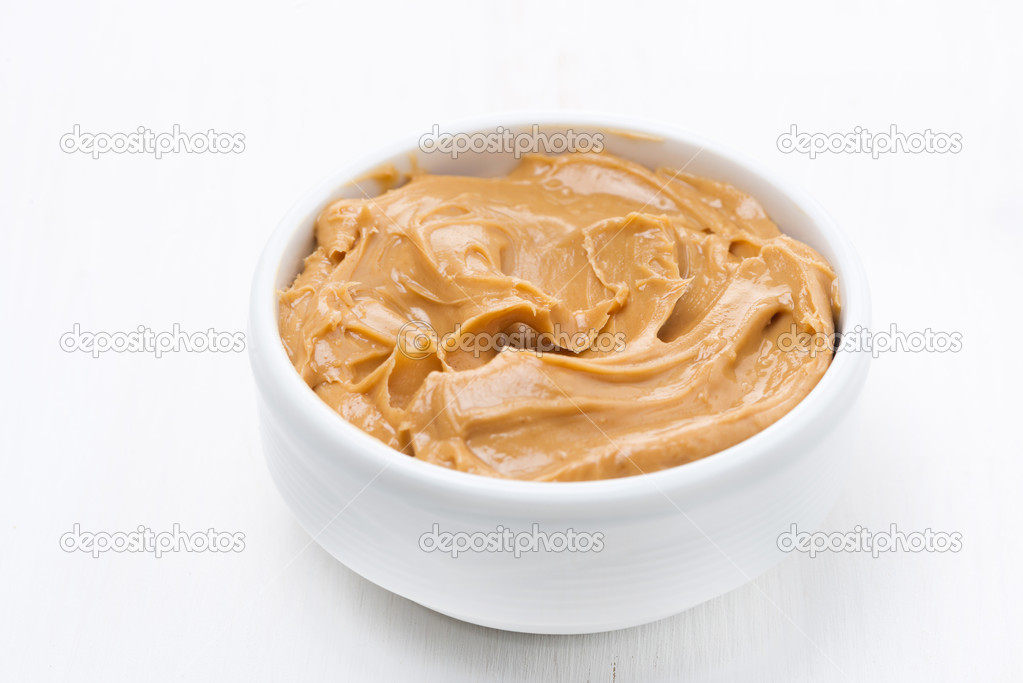 bowl of peanut butter on white wooden table
