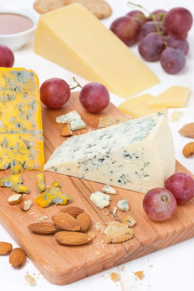 什锦的奶酪、 葡萄、 坚果在木板上 — 图库照片