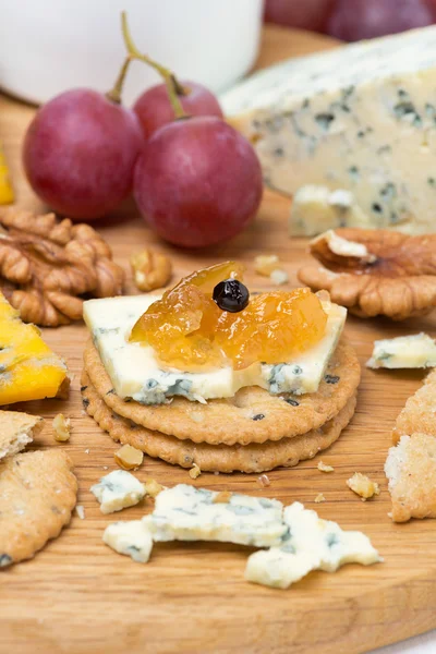 Крекеры с голубым сыром и яблочным джемом, орехами и виноградом — стоковое фото