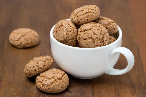 Biscoitos biscotti em uma xícara na mesa de madeira — Fotografia de Stock