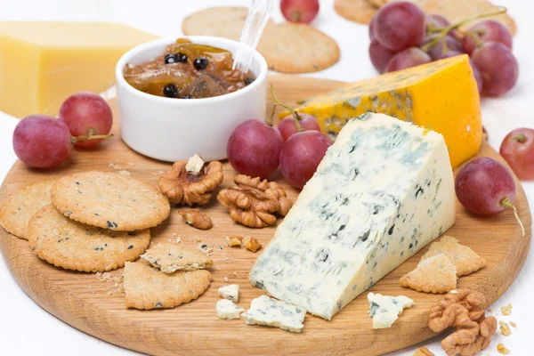 Quesos surtidos con moho, uvas, galletas, mermelada y frutos secos —  Fotos de Stock