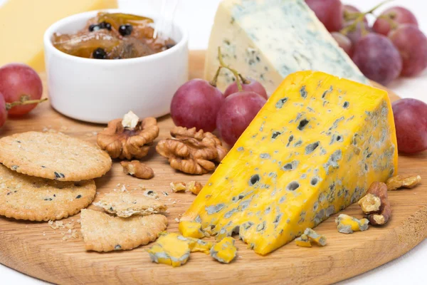 Verschiedene Käsesorten, Trauben, Cracker, Marmelade und Nüsse — Stockfoto