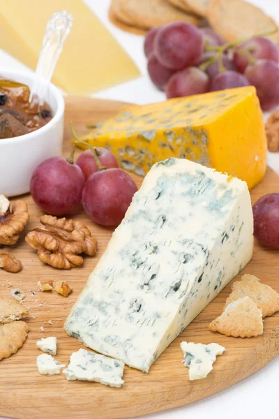 Fromages avec moisissure, raisins, craquelins, confiture et noix sur une planche — Photo