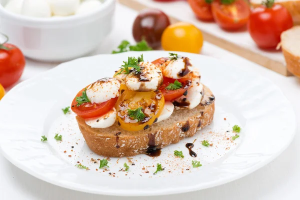 Piece of ciabatta with mozzarella and colorful cherry tomatoes — Stock Photo, Image