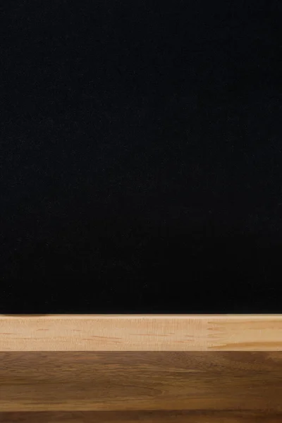 Holztisch und schwarzer Hintergrund für Text, vertikal — Stockfoto