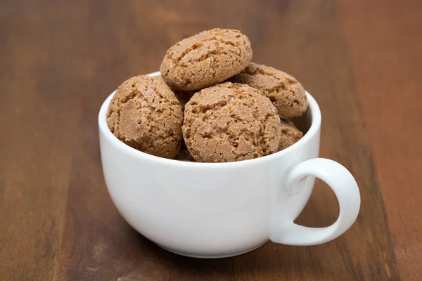 Biscotti cookies in een witte cup op een houten tafel — Stockfoto