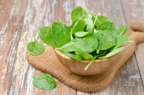 Fresh spinach in a wooden bowl — Stock Photo, Image