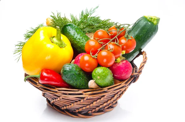 Assorted fresh vegetables and herbs in a basket — Stock Photo, Image