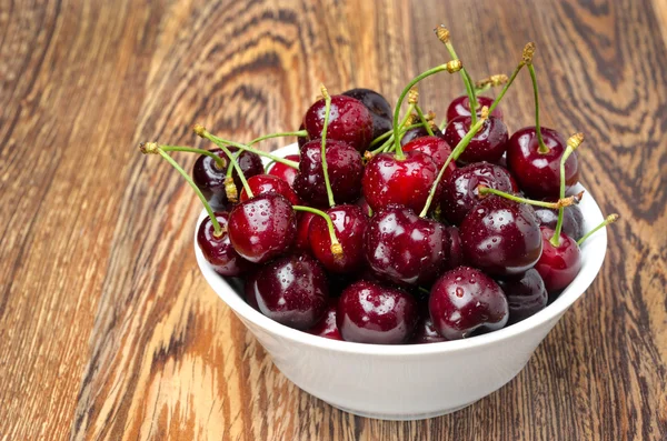 Bowl of fresh cherries on a wooden background, horizontal — Stock Photo, Image