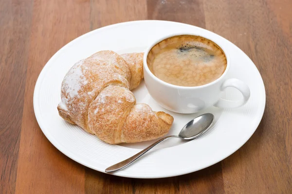 Fresh croissants on a plate and cup of coffee — Stock Photo, Image