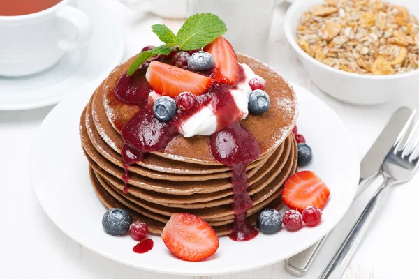 Pancakes with cream, fruit sauce and fresh berries for breakfast — Stock Photo, Image