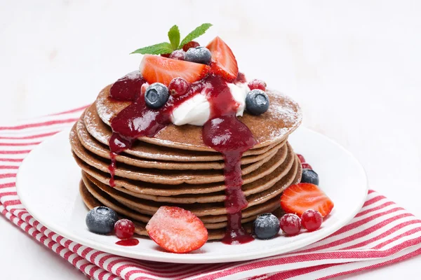 Pancakes with cream and berries on a white wooden table — Stock Photo, Image