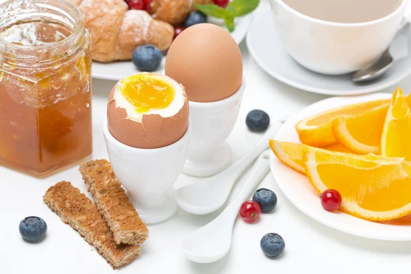 Desayuno con huevos, tostadas, cruasanes, bayas frescas, naranja —  Fotos de Stock