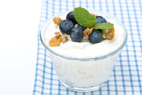 Homemade yogurt with blueberries and muesli in a glass, isolated — Stock Photo, Image