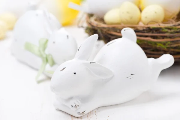 Conejos de Pascua blanca y cesta con huevos, primer plano —  Fotos de Stock