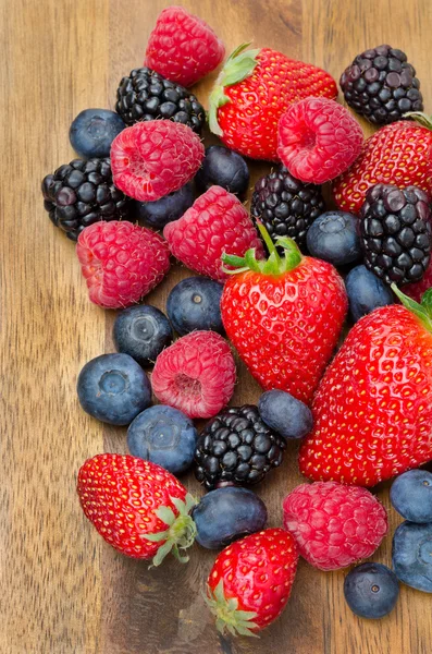 Assorted berries on wooden background — Stock Photo, Image