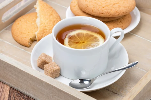 Черный чай с лимоном и печеньем — стоковое фото