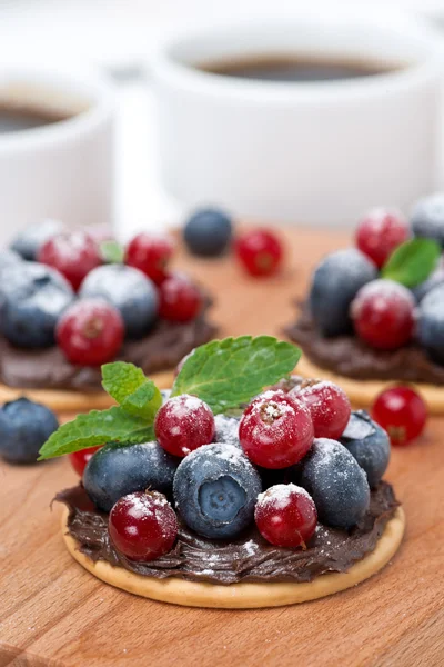 Cake with chocolate cream and fresh berries on a wooden board — Stock Photo, Image