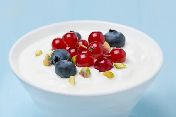Yogurt dulce fresco con bayas y pistachos, primer plano — Foto de Stock