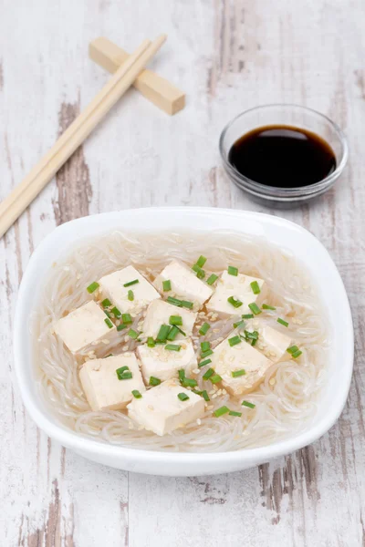 Sopa con fideos de arroz, tofu y cebollas verdes en un tazón — Foto de Stock