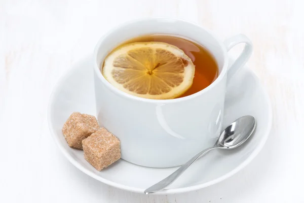 Черный чай с лимоном на белом деревянном столе — стоковое фото