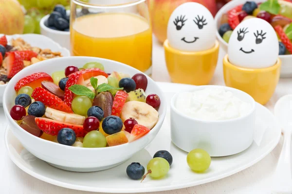 Свіжий фруктовий салат, вершки та пофарбовані яйця на сніданок — стокове фото