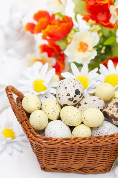 Cesta de mimbre con huevos de Pascua y flores — Foto de Stock