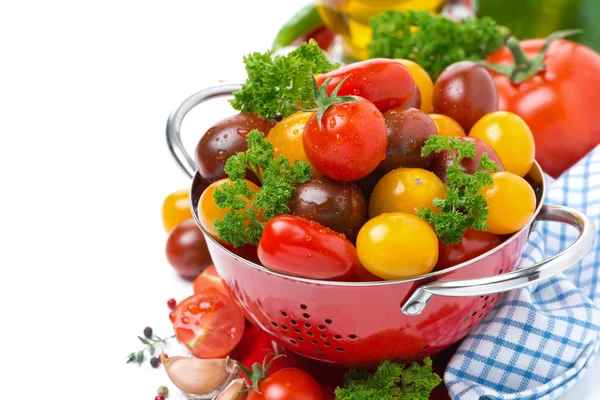 Muhtelif kiraz domates ve yeşillik içinde izole bir kevgir — Stok fotoğraf