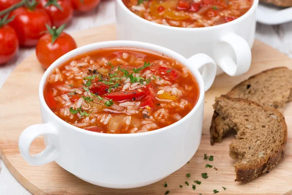 Tomatensoep met rijst, groenten en kruiden op houten tafel — Stockfoto