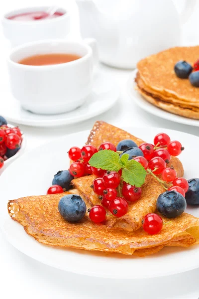 Frukost med pannkakor, färska bär och svart te på vit — Stockfoto