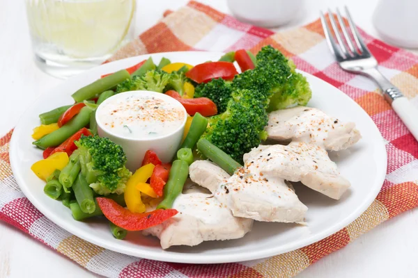 Filé de frango, verduras cozidas no vapor e molho de iogurte em uma chapa — Fotografia de Stock