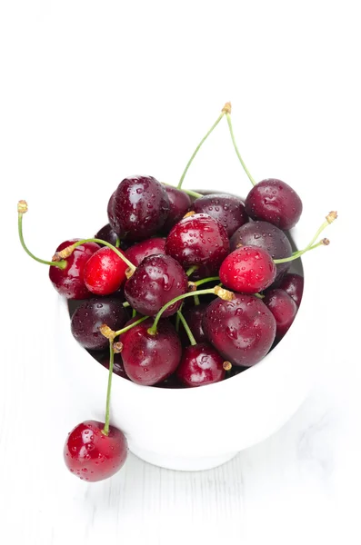 Bowl of fresh cherries on a white background, top view — Stock Photo, Image