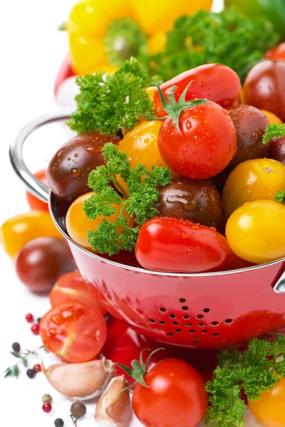 Verschiedene Kirschtomaten im Sieb, Gewürze und frische Kräuter — Stockfoto