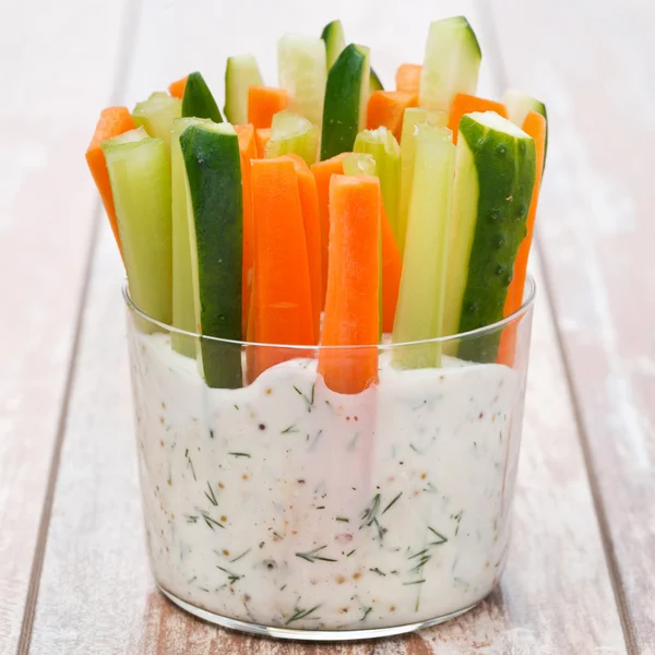 Färska grönsaker i en yoghurtsås i ett glas på träbord — Stockfoto