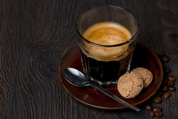 Espresso im Glas und Mandelkekse auf dunklem Hintergrund — Stockfoto