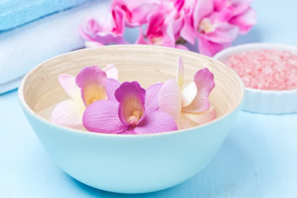 Mavi bir kase, havlu ve deniz tuzu spa için çiçekler — Stok fotoğraf