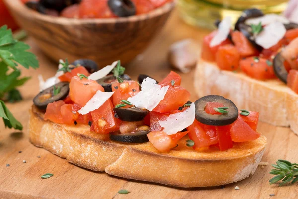 Ciabatta with tomatoes, olives, parmesan on a wooden board — Stock Photo, Image