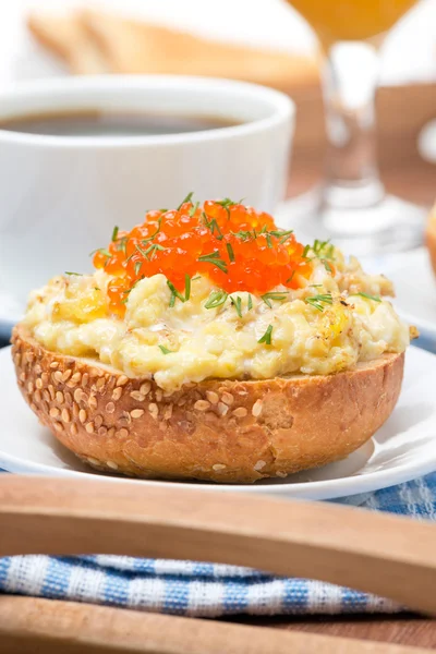 Scramble eggs with red caviar and greens on a wheat bun — Stock Photo, Image