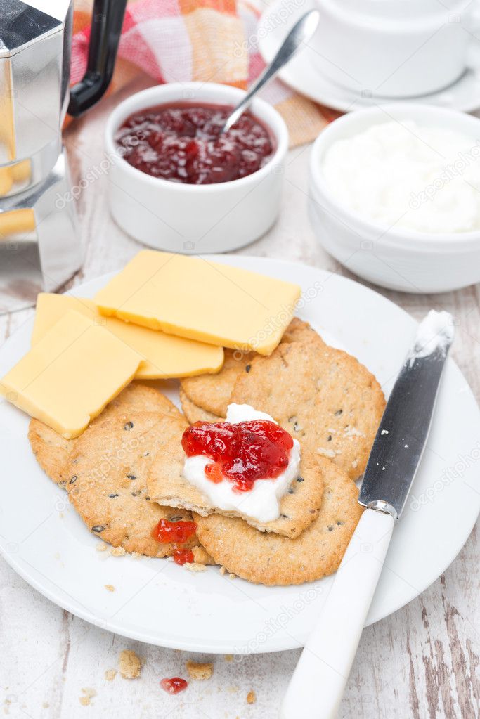 breakfast with crackers, cheese, cream and berry jam, top view