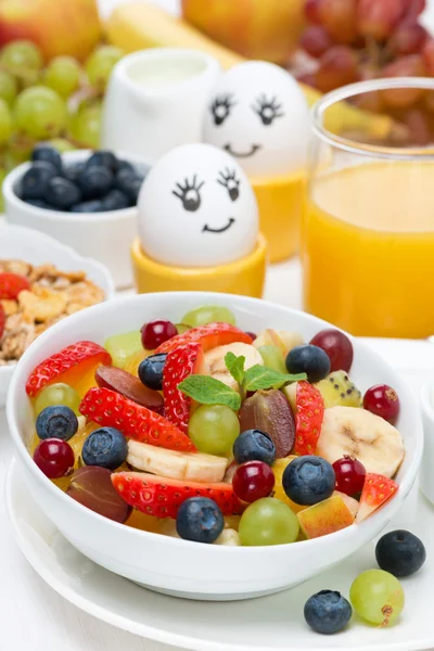 Färsk fruktsallad, grädde och målade ägg till frukost — Stockfoto