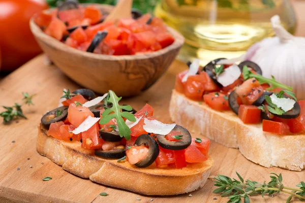 Ciabatta con tomates, aceitunas, parmesano sobre una tabla de madera —  Fotos de Stock