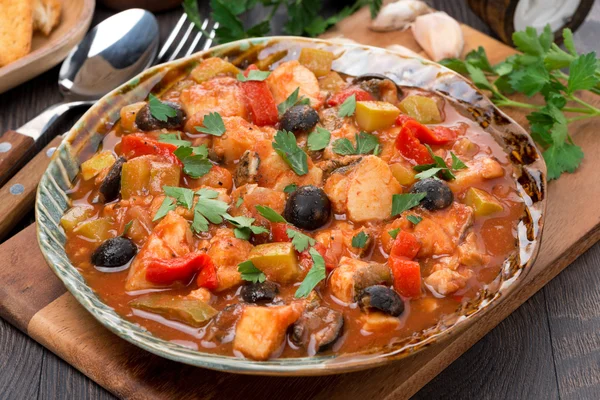 Fish stew with olives in tomato sauce on a plate — Stock Photo, Image