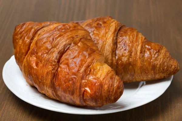 Frische Croissants auf einem Teller, Nahaufnahme — Stockfoto