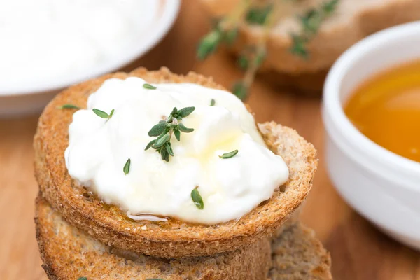 Toasts with goat cheese, honey and thyme, close-up — Stock Photo, Image